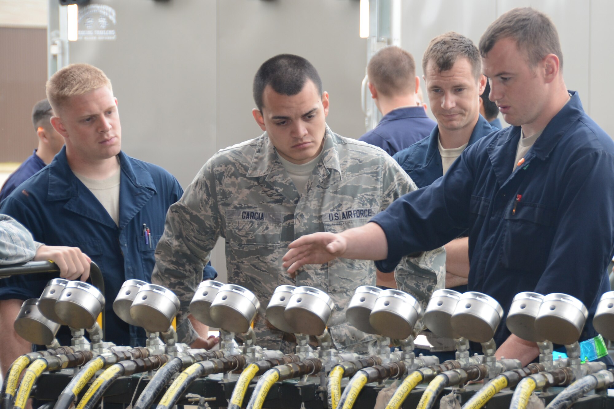 Staff Sgt. Shane Krafka (right), 48th Equipment Maintenance Squadron repair and reclamation craftsman, explains to Airmen the operation of air gauges in preparation for a crash recovery lift at Royal Air Force Lakenheath, England, July 27, 2013. The Airmen lifted an F-15C Eagle with high-capacity air bags as part of their annual training requirement to prepare for assisting with potential aircraft recovery operations. (U.S. Air Force photo by Airman 1st Class Trevor T. McBride/Released)