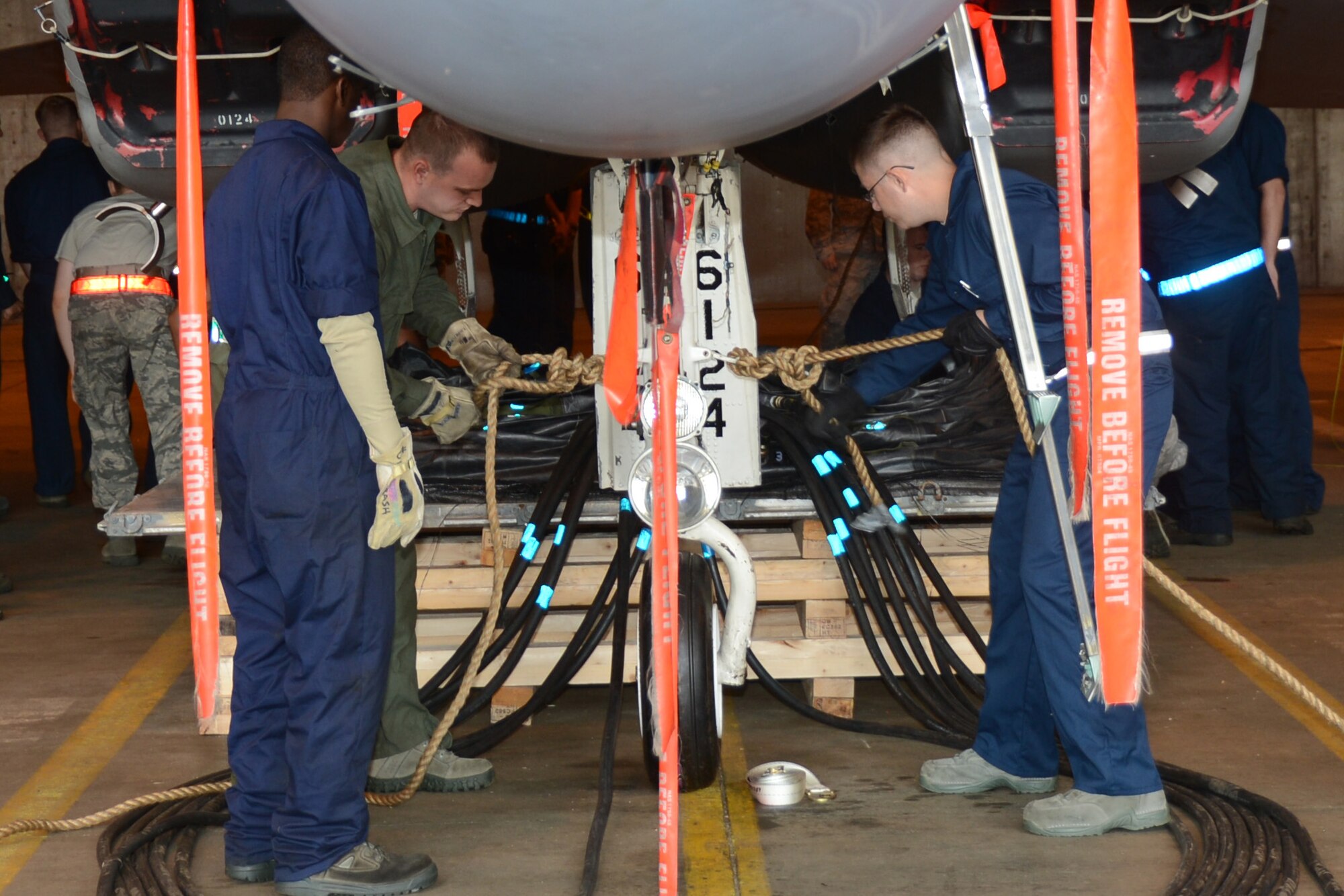 Airmen from the 48th Equipment Maintenance Squadron tie rope to an F-15C Eagle in preparation for crash recovery lift training at Royal Air Force Lakenheath, England, July 27, 2013. The Airmen lifted the aircraft with high-capacity air bags as part of their annual training requirement to prepare for assisting with potential aircraft recovery operations. (U.S. Air Force photo by Airman 1st Class Trevor T. McBride/Released)