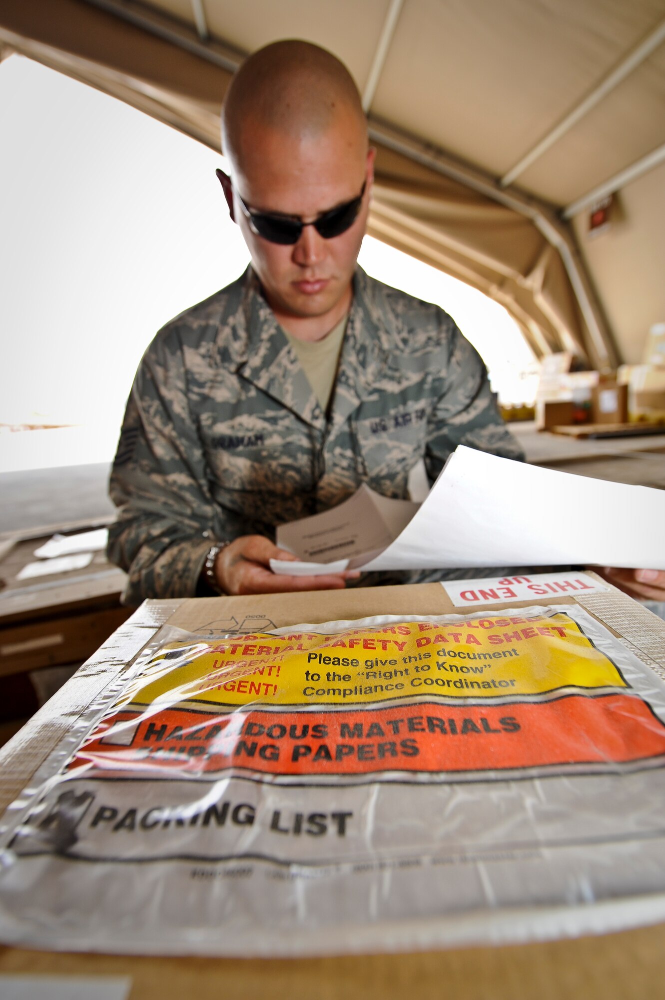 Tech. Sgt. Nicholas Graham inspects the paperwork for a hazardous materials labeled box at the 379th Air Expeditionary Wing in Southwest Asia, July 22, 2013. Graham is the 8th Expeditionary Air Mobility Squadron cargo processing and special handling NCO in charge currently on a remote tour here. (U.S. Air Force photo/Senior Airman Benjamin Stratton)