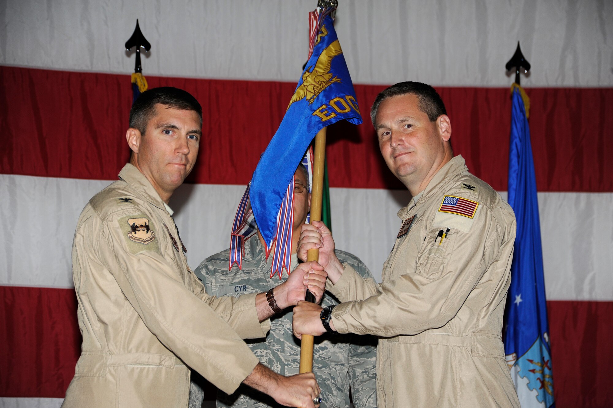 Colonel John M. Klein Jr., 386th Air Expeditionary Wing commander, left, passes the 386th  Expeditionary Operations Group guidon to Col. Douglas C. DeLaMater during an assumption of command ceremony at an undislosed location in Southwest Asia August 1, 2013. (U.S. Air Force photo by Master Sgt. Christopher A. Campbell)
