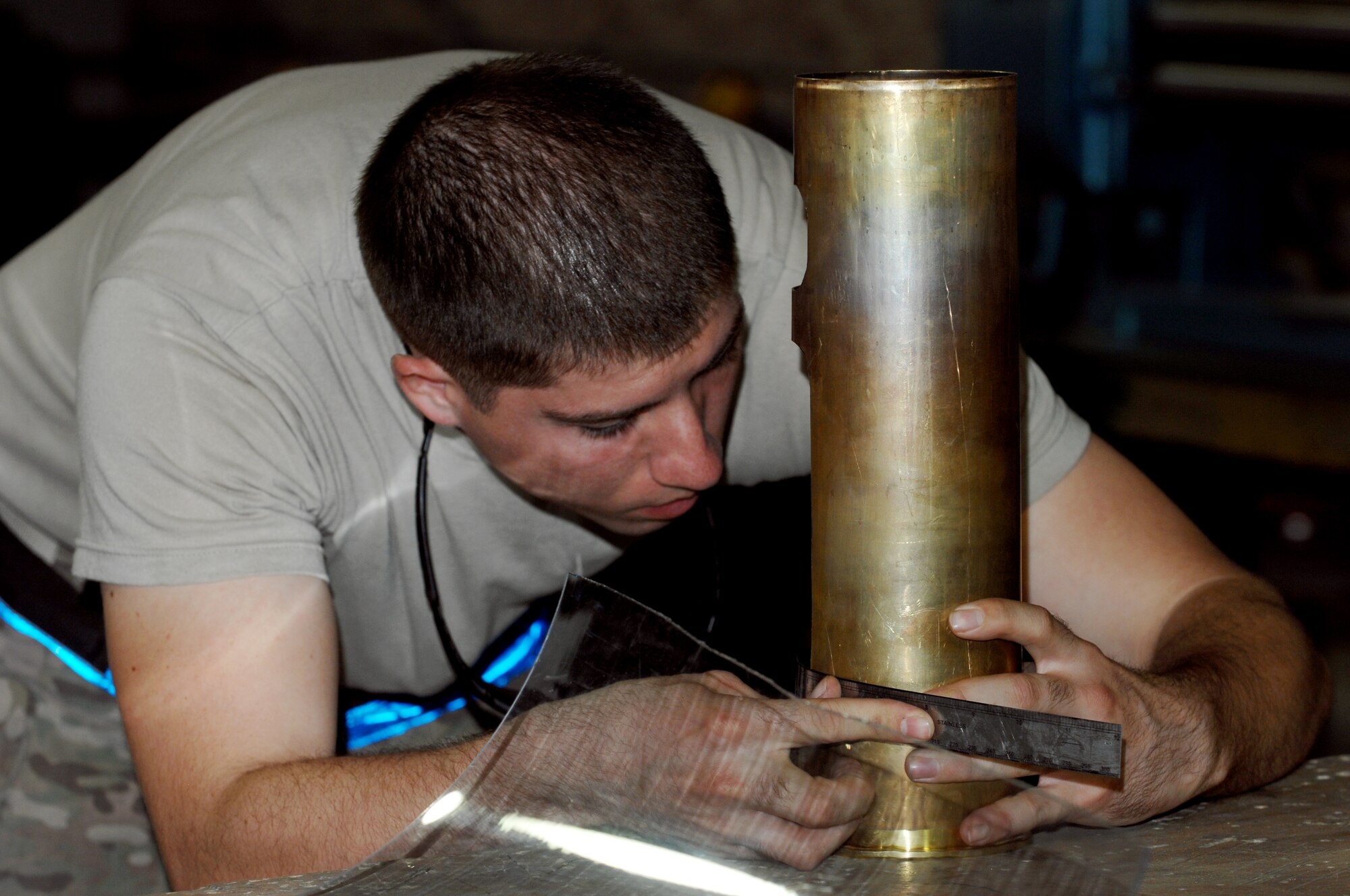 Senior Airman Christopher Lahey, 451st Expeditionary Maintenance Squadron fabrications flight aircraft metals technician, measures the remains of a 105 shell at Kandahar Airfield, Afghanistan, July 24, 2013. Many morale gifts or presents can be manufactured from expended munitions casings while allowing metal tech Airmen to practice their skills. Lahey is deployed from Little Rock Air Force Base, Ark. (U.S. Air Force photo by Senior Airman Jack Sanders)