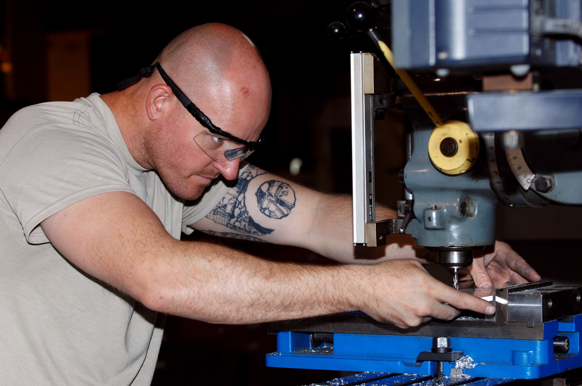 Staff Sgt. William Henrie, 451st Expeditionary Maintenance Squadron fabrications flight aircraft metals technician, maneuvers a metal plate under a drill at Kandahar Airfield, Afghanistan, July 24, 2013. The metal plate will be used as a piece of a light bar for a mine-resistant, ambush protected armored vehicle. Henrie is deployed from Spangdahlem Air Base, Germany. (U.S. Air Force photo by Senior Airman Jack Sanders)
