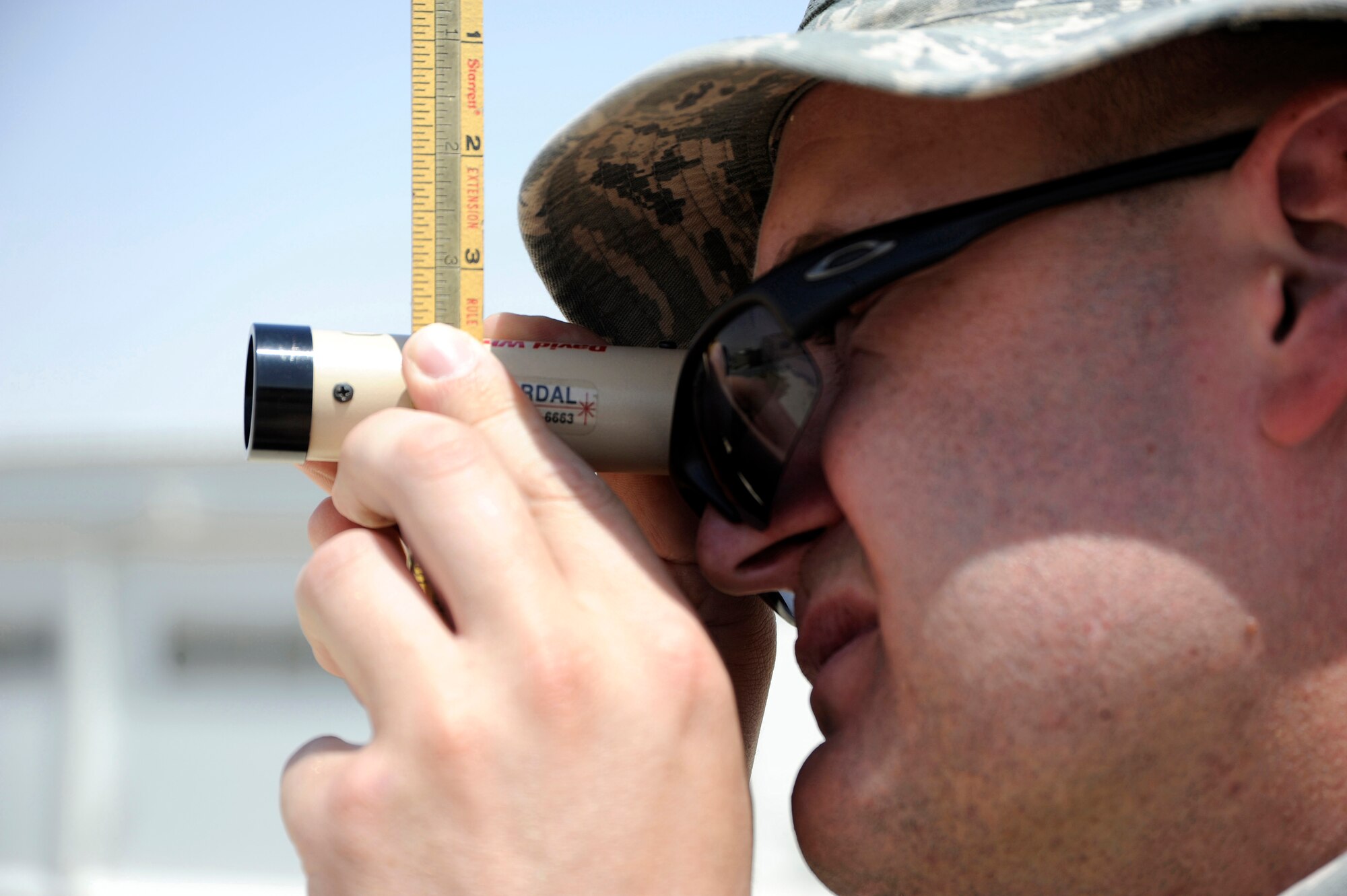 Tech. Sgt. Phillip Biwer, 386th Expeditionary Civil Engineer Squadron, heavy equipment operator, looks through a Peep Site level here, July 24, 2013. Biwer is the project manager for this site and needs to make sure all the base material or gatch is level. Biwer, a native of Plainfield Ill. is deployed out of the 110th Airlift Wing, Battle Creek, Mich., Air National Guard unit. (U.S. Air Force photo by Master Sgt. Christopher A. Campbell)