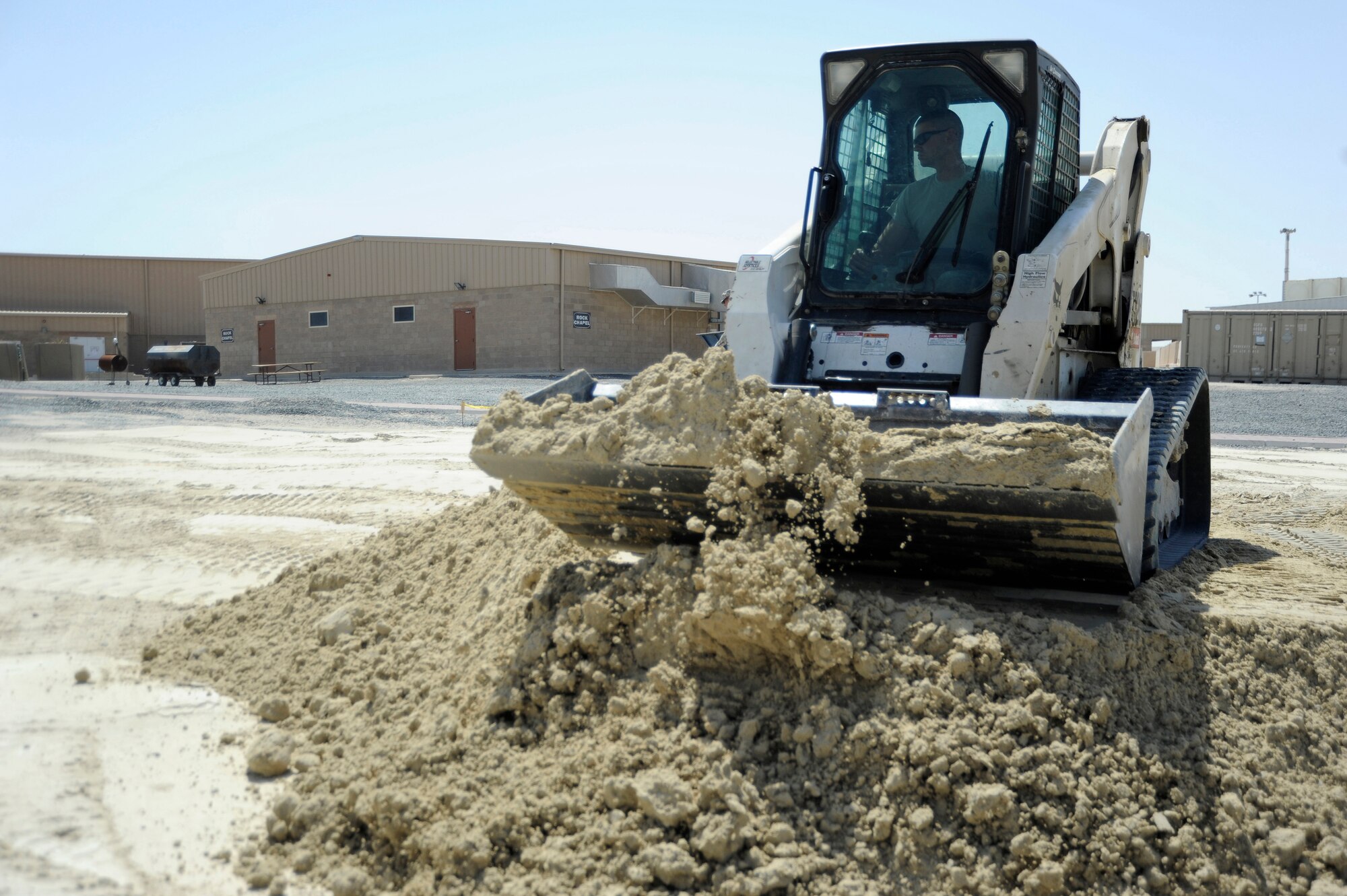 Tech. Sgt. Mark Ondersma, 386th Expeditionary Civil Engineer Squadron, heavy equipment operator, uses a Bobcat skid steer to move gatch around here, July 24, 2013. Ondersma is moving and leveling the gatch in preparation for a building. Ondersma is deployed out of the 110th Airlift Wing, Battle Creek, Mich., Air National Guard unit. (U.S. Air Force photo by Master Sgt. Christopher A. Campbell)