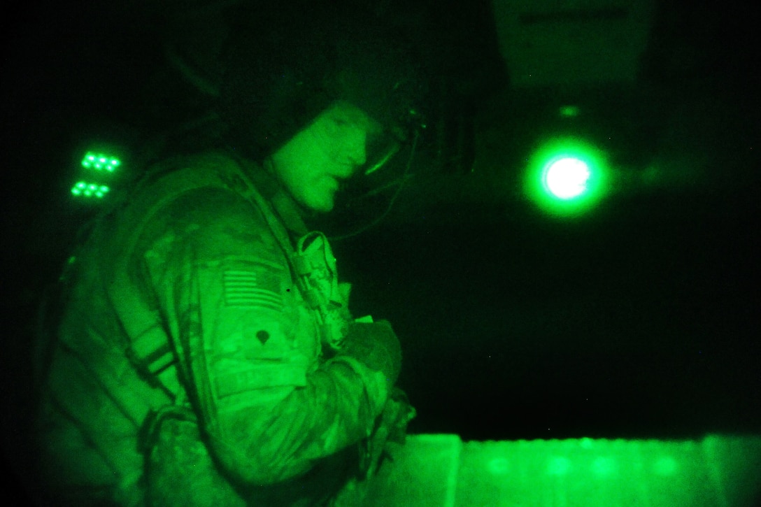 As seen through a night-vision device, U.S. Army Spc. Lloyd Hanley talks to pilots over his radio after he raised the rear ramp of a CH-47 Chinook helicopter before night missions on Forward Operating Base Fenty in Nangarhar province, Afghanistan, July 22, 2013. Hanley, a crew chief, is assigned to the 10th Mountain Division's Company B, 3rd Battalion, 10th General Support Aviation Battalion, 10th Combat Aviation Brigade.