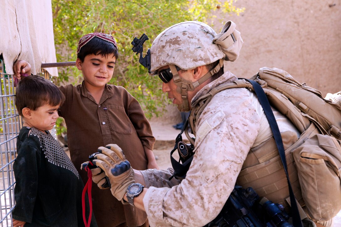 U.S. Marine Corps Warrant Officer Jimmy Chon talks with Afghan children during Operation Grizzly in Helmand province, Afghanistan, July 18, 2013. Chon is assigned to Fox Company, 2nd Battalion, 2nd Marine Regiment.