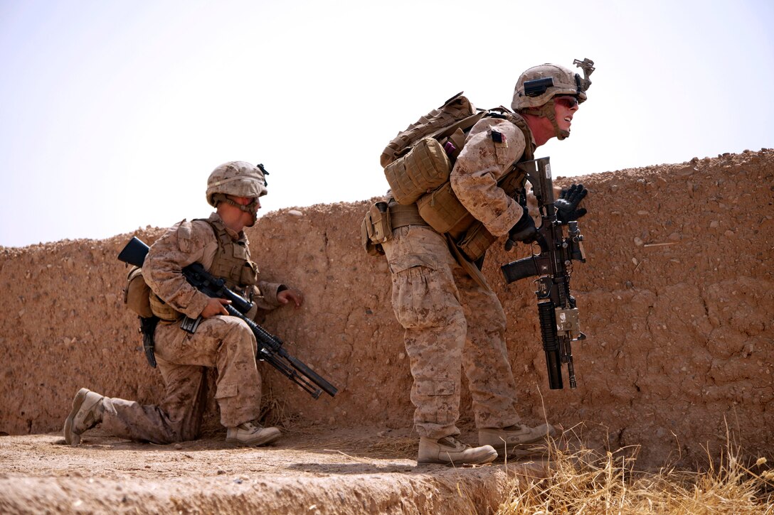 U.S. Marine Corps Cpl. Michael Emerson, left, and U.S. Marine Corps Lance Cpl. John J. McConnell scan the surrounding area after taking enemy fire during Operation Grizzly in Helmand province, Afghanistan, July 18, 2013. Emerson and McConnell are assigned to Fox Company, 2nd Battalion, 2nd Marine Regiment.