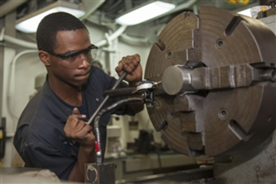 U.S. Navy Fireman Christopher Williams centers a piece of carbon stock metal in a lathe aboard the amphibious assault ship USS Bonhomme Richard (LHD 6) as the ship operates in the Coral Sea on July 29, 2013.  Williams is a Navy machinery repairman aboard the ship.  The Bonhomme Richard is taking part in exercise Talisman Saber, a biennial exercise that enhances multilateral collaboration between U.S. and Australian forces for future combined operations, humanitarian assistance, and natural disaster response.  