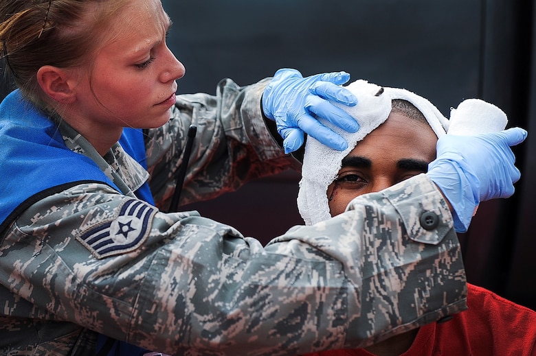 Staff Sgt. April Welch wraps the head of a simulated victim during a Major Accident Response Exercise July 24, 2013, at Little Rock Air Force Base, Ark. The purpose of the MARE was to test the response of the base’s and the city of Jacksonville’s first responders. Welch is a medical technician assigned to the 19th Aerospace Medicine Squadron. (U.S. Air Force photo/Airman 1st Class Cliffton Dolezal)