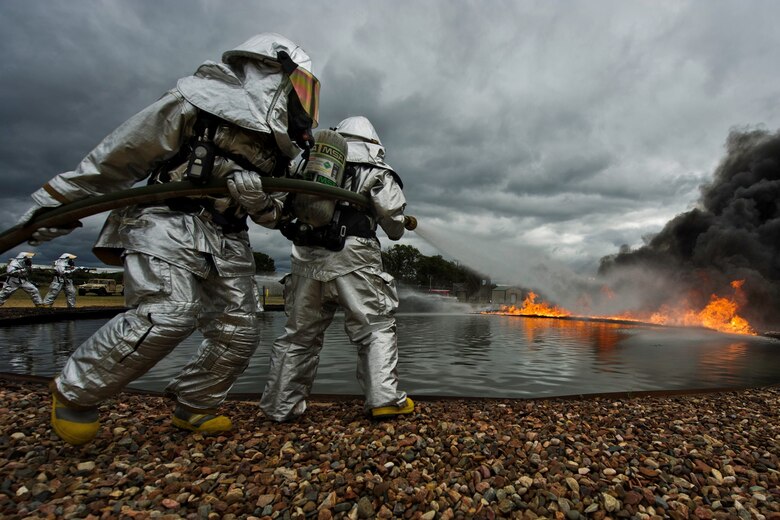 Firefighters maneuver a fire hose to attack fires in support of Warrior Exercise 86-13-01/Exercise Global Medic 2013 July 27, at Fort McCoy, Wis. WAREX provides units an opportunity to rehearse military maneuvers and tactics. Held in conjunction with WAREX, Global Medic is an annual joint-field training exercise designed to replicate all aspects of theater combat medical support. (U.S. Air Force photo/Staff Sgt. Jared Becker)