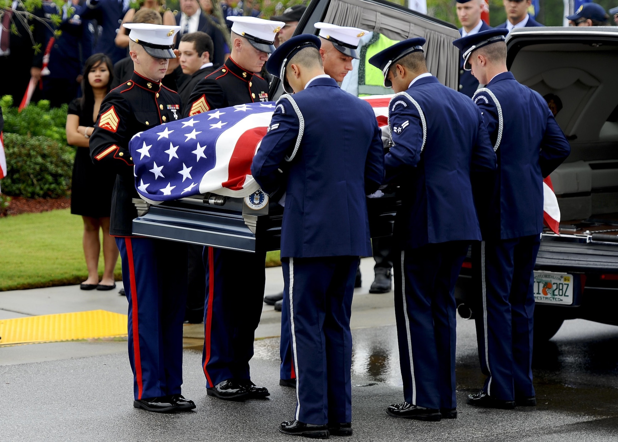 Pallbearers, made up of Airmen and Marines, lift the casket of retired U.S. Air Force Col. George “Bud” Day from his hearse during the funeral service at Barrancas National Cemetery on Naval Air Station Pensacola, Fla., Aug. 1, 2013. Day, a Medal of Honor recipient and combat pilot with service in World War II, Korea and Vietnam, passed away July 27 at the age of 88. (U.S. Air Force Photo/ Airman 1st Class Jeffrey Parkinson) 
