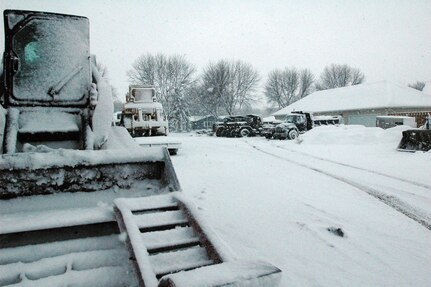 Vehicles sit covered in snow outside the El Zagal Shrine in Fargo, N.D., while the North Dakota National Guard's Quick Reaction Force waits for a mission.