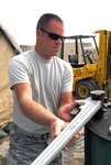 Senior Airman Ryan McClung of the West Virginia Air National Guard prepares a boiler for installation at Joint Task Force Guantanamo's Camp Justice, March 30, 2009. The boiler will allow Troopers at Joint Task Force Guantanamo's Camp Justice to take warm showers.