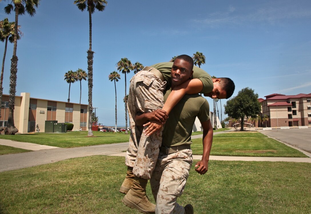Lance Cpl. Anthony Hendrix, conducts a fireman carry with Pfc. Diego Retamozo, both administration specialists, Command Element, 15th Marine Expeditionary Unit, during combat-oriented physical training aboard Camp Pendleton, Calif., Aug. 1. The Marines are preparing for the Combat Fitness Test, an annual physical fitness test that challenges Marines’ physical and mental readiness for the rigors of today’s combat operations. Hendrix, 21, McLeansville, N.C. and Retamozo, 20, is from Perth Amboy, N.J.  (U.S. Marine Corps Photo by Cpl. Emmanuel Ramos/Released)
