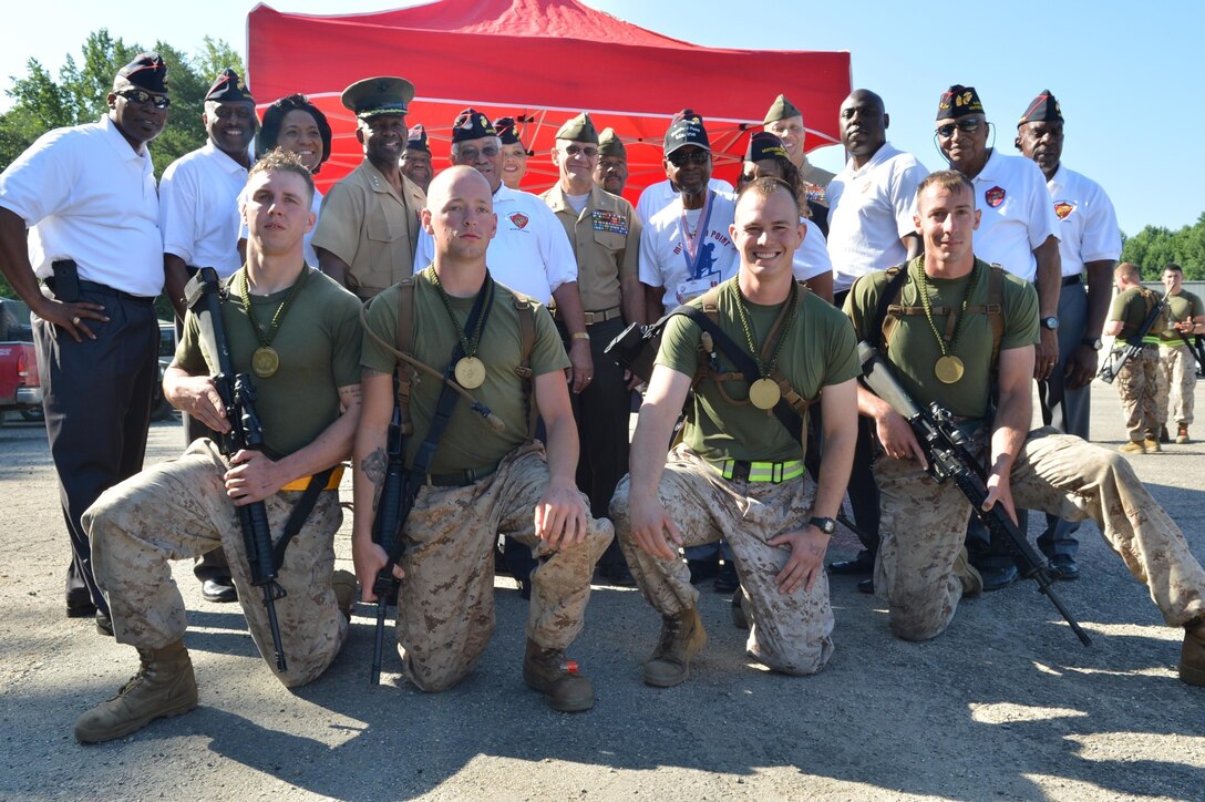 Capt. Peter Thermos, Cpl. Kevin Simek, Cpl. Seth Dennis and Cpl. John Bandy, the fastest team, poses for a picture with the VIPs of the 2013 Inaugural Montford Point Marine Memorial Biathlon held Camp Barrett and WTBn’s Range 4 aboard Marine Corps Base Quantico on July 26. Members of the Montford Point Association were a few of the VIPs present.