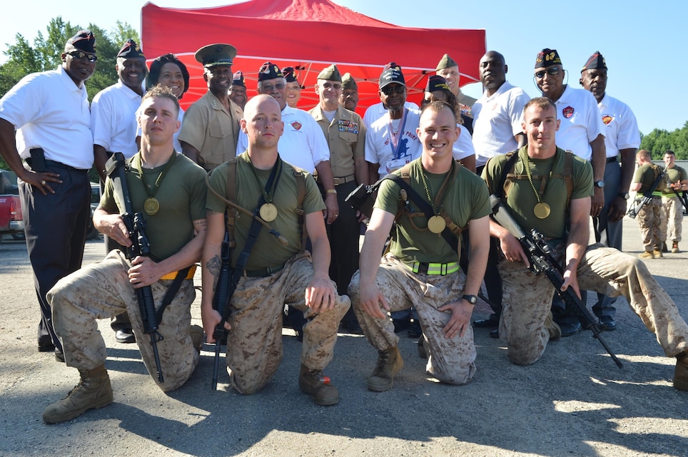 Capt. Peter Thermos, Cpl. Kevin Simek, Cpl. Seth Dennis and Cpl. John Bandy, the fastest team, poses for a picture with the VIPs of the 2013 Inaugural Montford Point Marine Memorial Biathlon held Camp Barrett and WTBn’s Range 4 aboard Marine Corps Base Quantico on July 26. Members of the Montford Point Association were a few of the VIPs present.