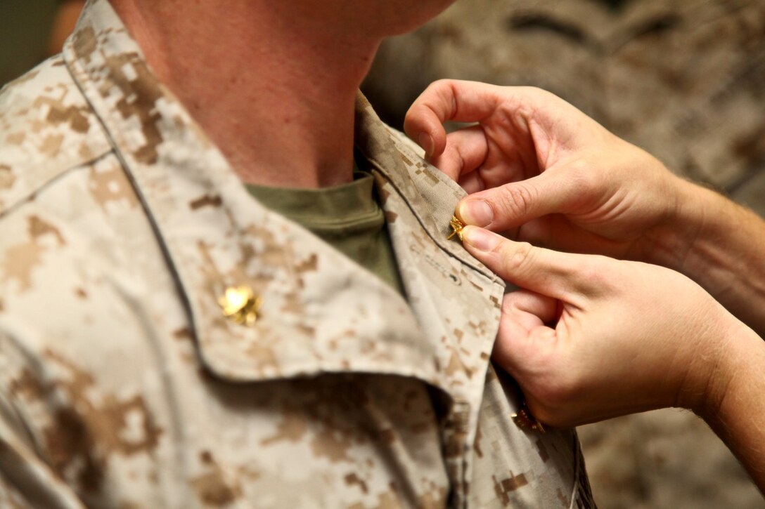 Heather Myers pins her husband, Maj. Daniel Myers, intelligence officer, Command Element, 15th Marine Expeditionary Unit, with gold oak leaves during his promotion ceremony held in the unit’s conference room aboard Camp Pendleton, Calif., Aug. 1. Myers, 33, is from McLeansville, N.C. (U.S. Marine Corps Photo by Cpl. Emmanuel Ramos/Released)