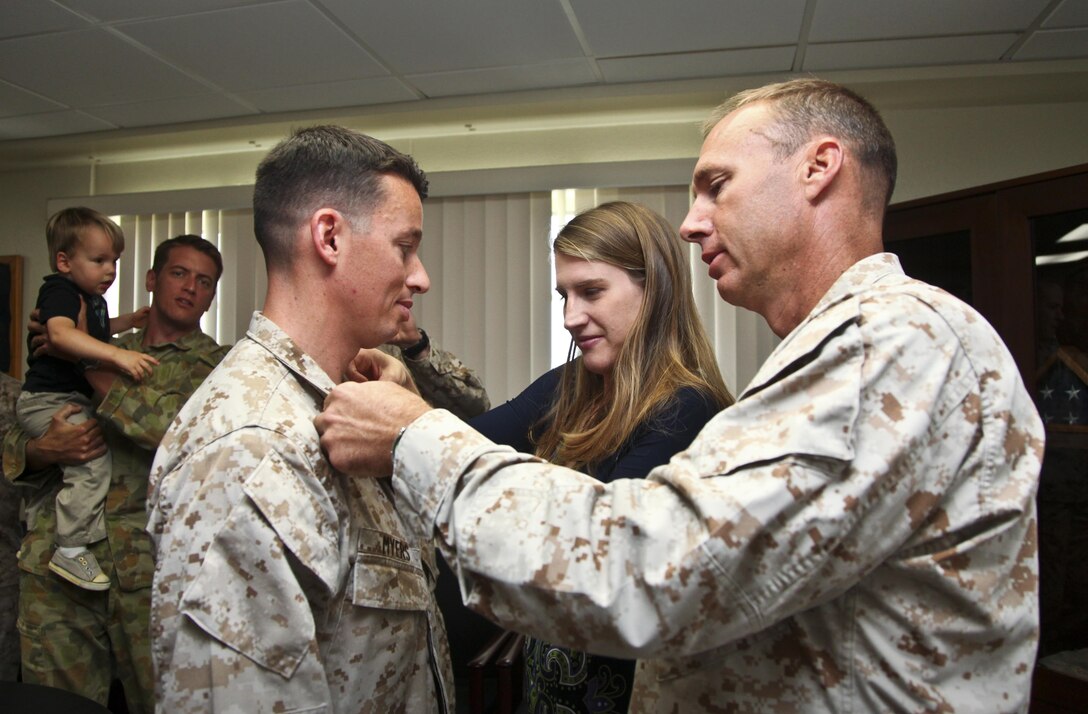 Lieutenant Col. William D. Wischmeyer, executive officer, 15th Marine Expeditionary Unit, and Heather Myers, spouse of Daniel Myers, pin Maj. Daniel Myers, intelligence officer, Command Element, 15th MEU, with gold oak leaves during his promotion ceremony held in the unit’s conference room aboard Camp Pendleton, Calif., Aug. 1. Myers, 33, is from McLeansville, N.C. (U.S. Marine Corps Photo by Cpl. Emmanuel Ramos/Released)