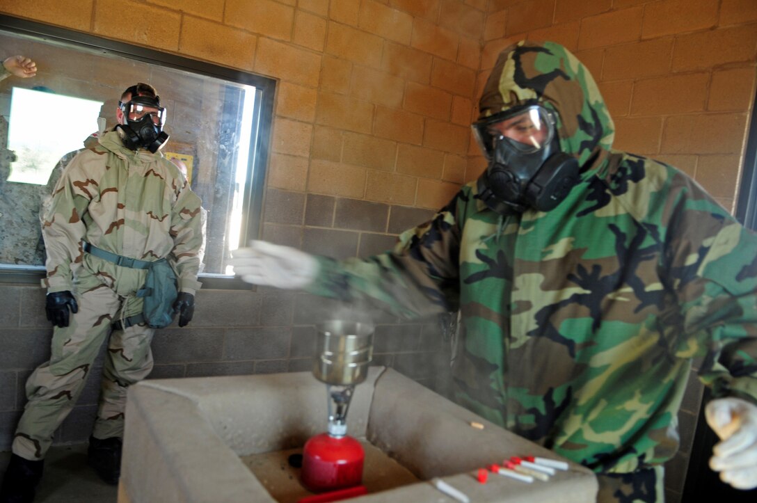 Marine Aircraft Group 13 chemical, biological, radiological and nuclear defense specialist Lance Cpl. Marco Luciano Romo, a native of El Paso, Texas, wafts CS (2-chlorobenzalmalononitrile) crystals in the Marine Corps Air Station Yuma, Ariz., gas chamber for even disbursement during an individual protective equipment confidence exercise.