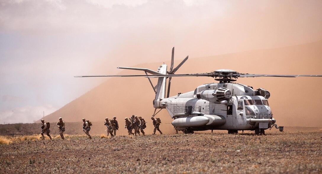 A CH-53E offloads a platoon of Marines with Echo Company, 2nd Battalion, 3rd Marine Regiment, into a military operations in urban terrain training facility as part of Exercise Lava Viper in the Pohakuloa Training Area, Hawaii July 18, 2013. The Marines were conducting the raid to clear the MOUT town and capture a high value individual believed to be an enemy battalion commander. (U.S. Marine Corps photo by Cpl. Matthew Callahan)