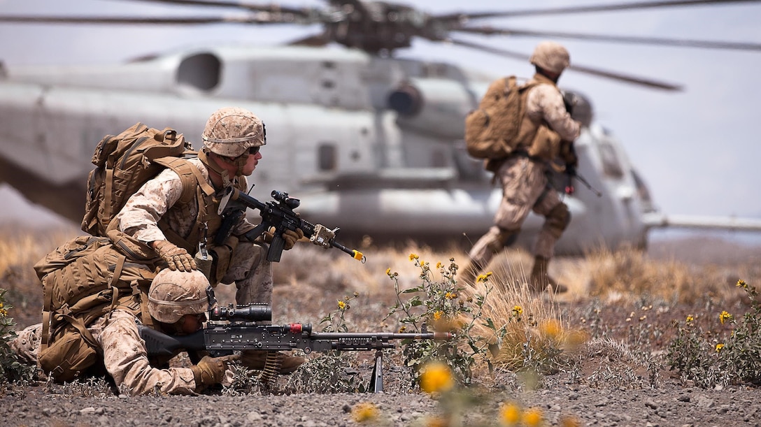 Pfc. Ryan Parker, a San Matel, Calif. native (closest), and Cpl. Liam Lamarine, from Goffstown, N.H., hold landing zone security down an avenue of approach while their fellow Marines scramble toward a military operations in urban terrain town to conduct a raid in search of a high value individual believed to be an enemy battalion commander as part of Exercise Lava Viper at Pohakuloa Training Area, Island of Hawaii, July 18, 2013. The medium machine gunners are with weapons platoon, Echo Company, 2nd Battalion, 3rd Marine Regiment. (U.S. Marine Corps photo by Cpl. Matthew Callahan)