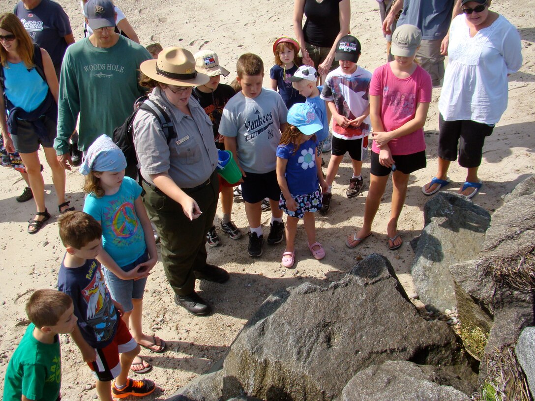 Amy Pettigrew, seasonal park ranger, at the Cape Cod Canal Field Office, Sandwich, Mass., takes a group out for a beach exploration walk along the shoreline at the canal’s east end. During this 3/4-mile walk, the group explores life along the beach and focuses on the intertidal zone.