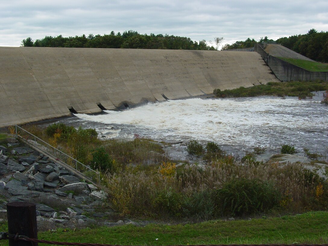Mansfield Hollow Dam releasing water during the 2005 high water event, Mansfield, Conn. The U.S. Army Corps of Engineers regulates the flow of the Natchaug River, which exits the dam, by raising or lowering five, 5.5 feet-by-7 feett hydraulically operated sluice gates from within the dam. The watershed above Mansfield Hollow Dam encompasses an area of 159 square miles.