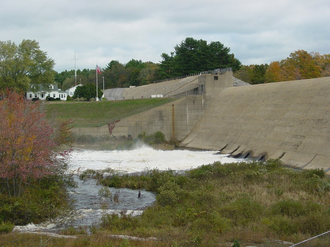 Mansfield Hollow Dam from the south abutment releasing water during the 2005 high water event, Mansfield, Conn. The U.S. Army Corps of Engineers regulates the flow of the Natchaug River, which exits the dam, by raising or lowering five, 5.5 feet-by-7 feett hydraulically operated sluice gates from within the dam. The watershed above Mansfield Hollow Dam encompasses an area of 159 square miles.