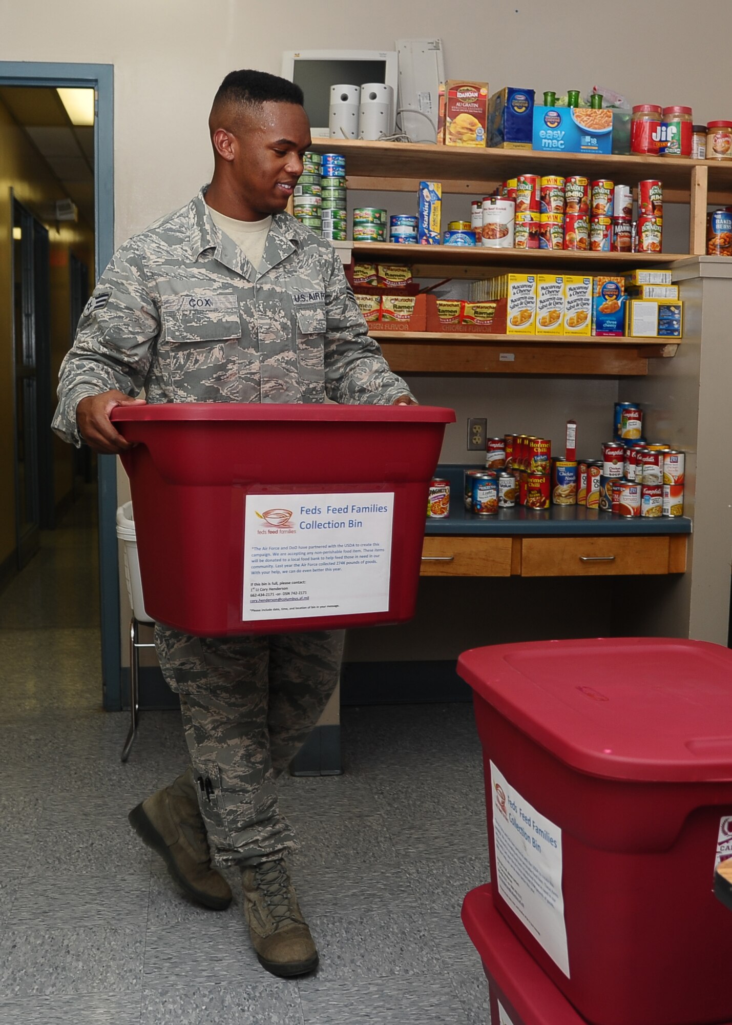Senior Airman Parrish Cox, 14th Medical Operations Squadron, brings in a container full of donations August 2 to United Way for the Feds Feed Families campaign that runs from the beginning of June to the end of August. Since the campaign began, Columbus Air Force Base has donated 1,800 pounds of food and is hoping to exceed last year's donation total of 3,300 pounds. Non-perishable items can be dropped off in red collection bins around base in locations such as the Commissary, Base Exchange, Columbus Club, Bowling Alley and Fitness Center. (U.S. Air Force Photo/ Airman 1st Class Stephanie Englar)