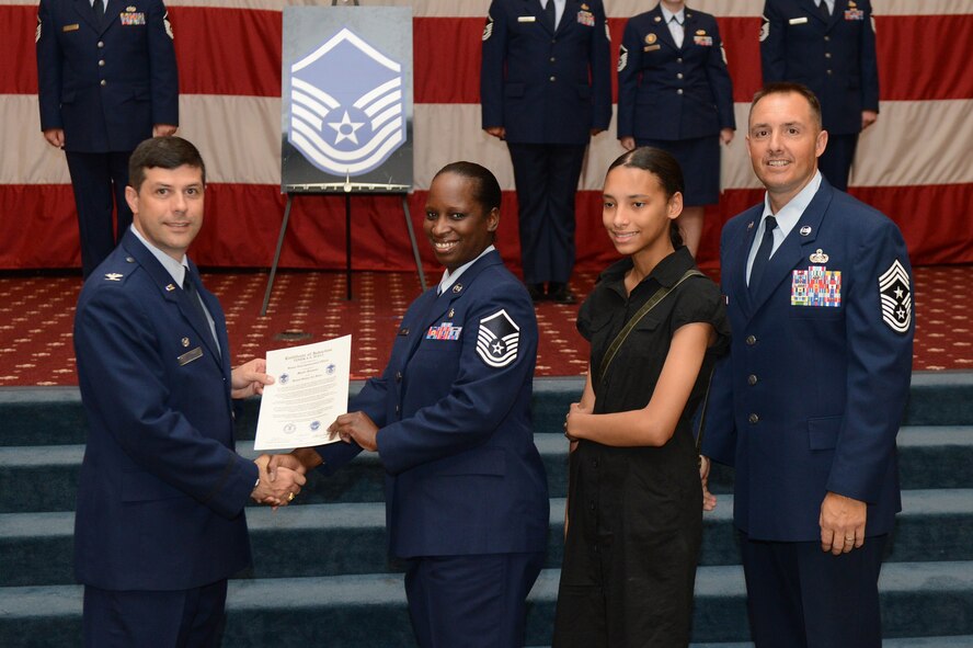 Master Sgt. Timika Hall, from the 2nd Medical Group, receives a certificate of promotion from Col. Andrew Gebara, 2nd Bomb Wing commander, and Chief Master Sgt. Curtis Storms, 2nd BW command chief, during the July Wing Promotion Ceremony on Barksdale Air Force Base, La., July 31, 2013. (U.S. Air Force photo/Senior Airman Micaiah Anthony)