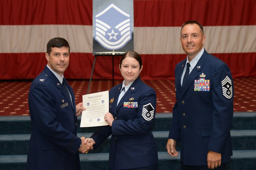 Master Sgt. Donna Barnhill, from the 2nd Bomb Wing, receives a certificate of promotion from Col. Andrew Gebara, 2nd Bomb Wing commander, and Chief Master Sgt. Curtis Storms, 2nd BW command chief, during the July Wing Promotion Ceremony on Barksdale Air Force Base, La., July 31, 2013. (U.S. Air Force photo/Senior Airman Micaiah Anthony)