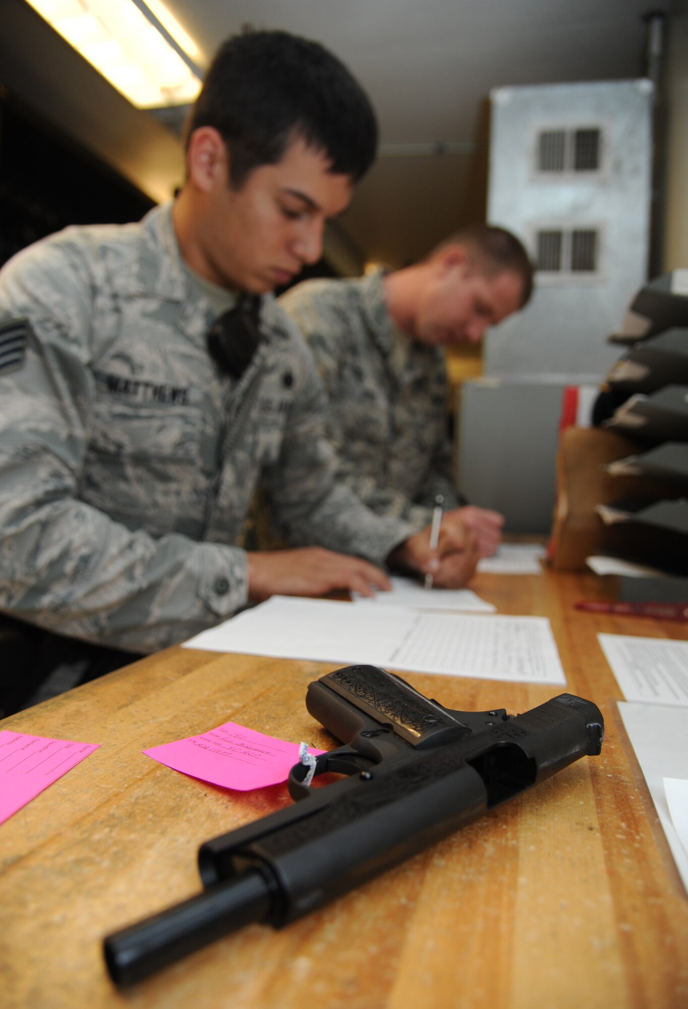 Staff Sgt. James Matthews, 81st Security Forces Squadron, and Staff Sgt. Michael O’Neil, 81st SFS armory NCO in charge, complete forms for privately owned weapons registration for storing inside the armory Aug. 2, 2013, at the 81st SFS building, Keesler Air Force Base, Miss.  The 81st SFS armory keeps weapons, ammunition, shared gear, and stores privately owned weapons for Keesler residents.  (U.S. Air Force photo by Kemberly Groue)