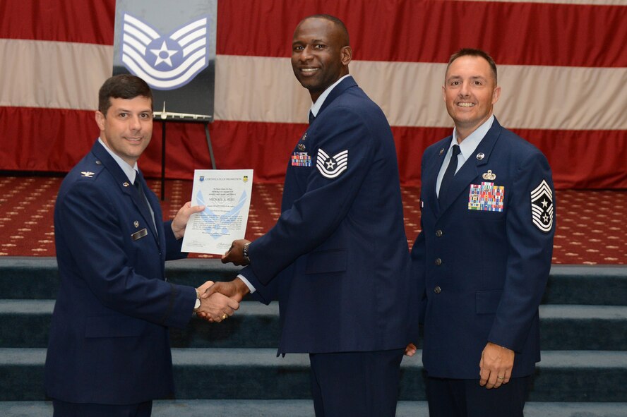 Tech. Sgt. Michael Reed, from the 2nd Civil Engineer Squadron, receives a certificate of promotion from Col. Andrew Gebara, 2nd Bomb Wing commander, and Chief Master Sgt. Curtis Storms, 2nd BW command chief, during the July Wing Promotion Ceremony on Barksdale Air Force Base, La., July 31, 2013. (U.S. Air Force photo/Senior Airman Micaiah Anthony)