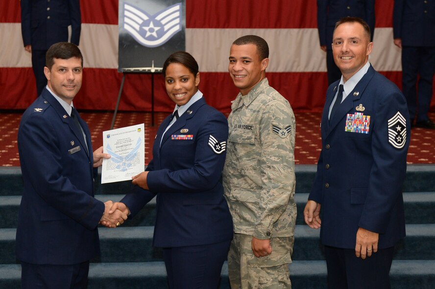 Staff Sgt. Ismary Chevis, from the 2nd Medical Support Squadron, receives a certificate of promotion from Col. Andrew Gebara, 2nd Bomb Wing commander, and Chief Master Sgt. Curtis Storms, 2nd BW command chief, during the July Wing Promotion Ceremony on Barksdale Air Force Base, La., July 31, 2013. (U.S. Air Force photo/Senior Airman Micaiah Anthony)
