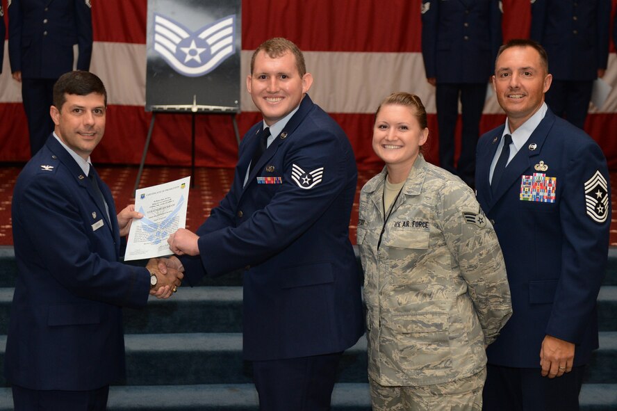 Staff Sgt. Colton Durham, from the 26th Operational Weather Squadron, receives a certificate of promotion from Col. Andrew Gebara, 2nd Bomb Wing commander, and Chief Master Sgt. Curtis Storms, 2nd BW command chief, during the July Wing Promotion Ceremony on Barksdale Air Force Base, La., July 31, 2013. (U.S. Air Force photo/Senior Airman Micaiah Anthony)
