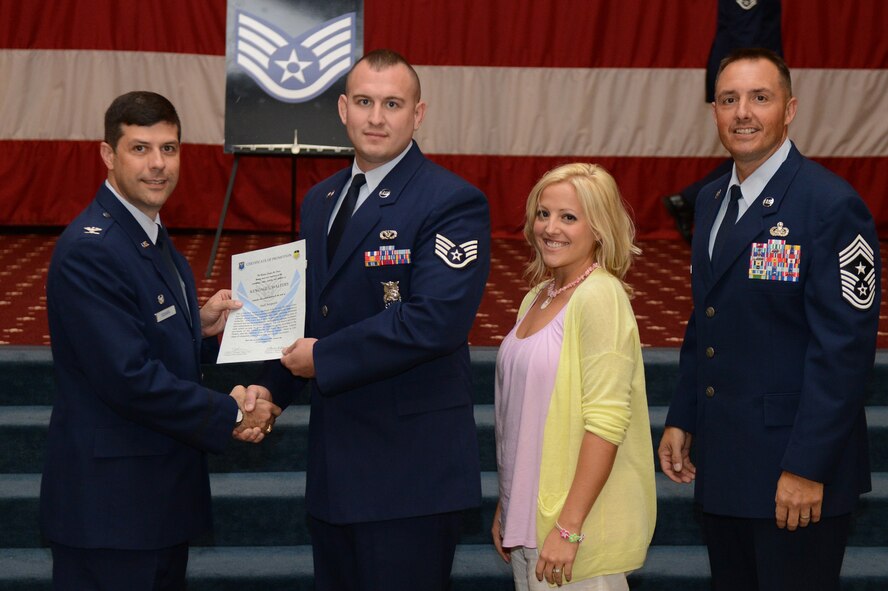 Staff Sgt. Kendal Walters, from the 2nd Civil Engineer Squadron, receives a certificate of promotion from Col. Andrew Gebara, 2nd Bomb Wing commander, and Chief Master Sgt. Curtis Storms, 2nd BW command chief, during the July Wing Promotion Ceremony on Barksdale Air Force Base, La., July 31, 2013. (U.S. Air Force photo/Senior Airman Micaiah Anthony)