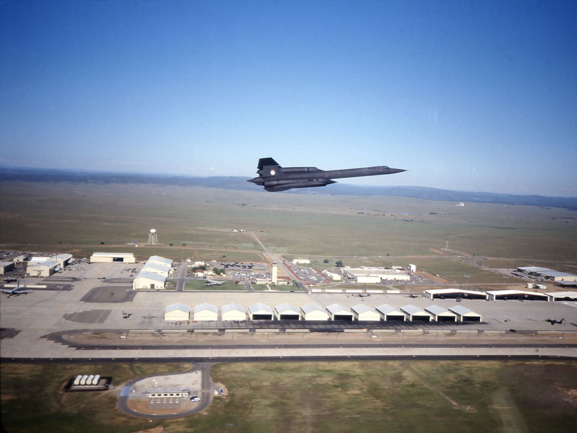 A SR-71 Blackbird flies over Beale Air Force Base in an undated photo. Blackbird hangars are clearly visible in lower portion of the photo. (Courtesy photo)  