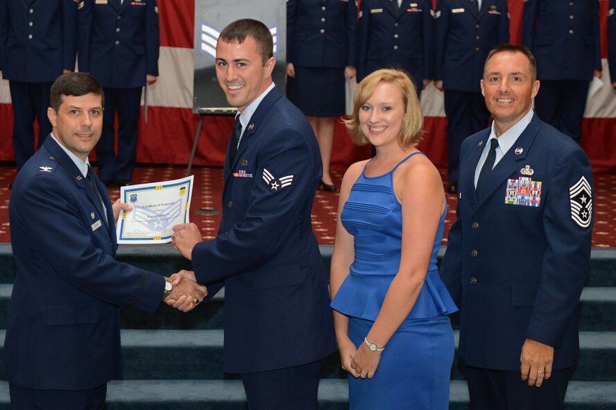Senior Airman Ryan Hamilton, from the 2nd Munitions Squadron, receives a certificate of promotion from Col. Andrew Gebara, 2nd Bomb Wing commander, and Chief Master Sgt. Curtis Storms, 2nd BW command chief, during the July Wing Promotion Ceremony on Barksdale Air Force Base, La., July 31, 2013. (U.S. Air Force photo/Senior Airman Micaiah Anthony)
