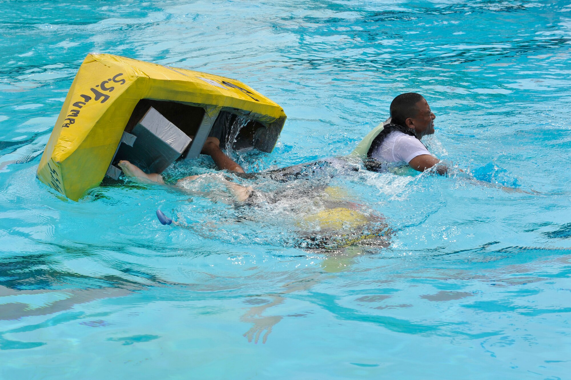 Members from Team Scott participate in the 3rd annual Cardboard Boat Regatta at the Scott pool Aug. 2, 2013. The race, hosted by the 375 Force Support Squadron, featured 23 teams and gave away prizes for best decorated boat, fastest sinking boat and best dressed contestants. Gift cards were also given to the first, second and third place winners. (U.S. Air Force photo/Staff Sgt. Christopher Boitz)