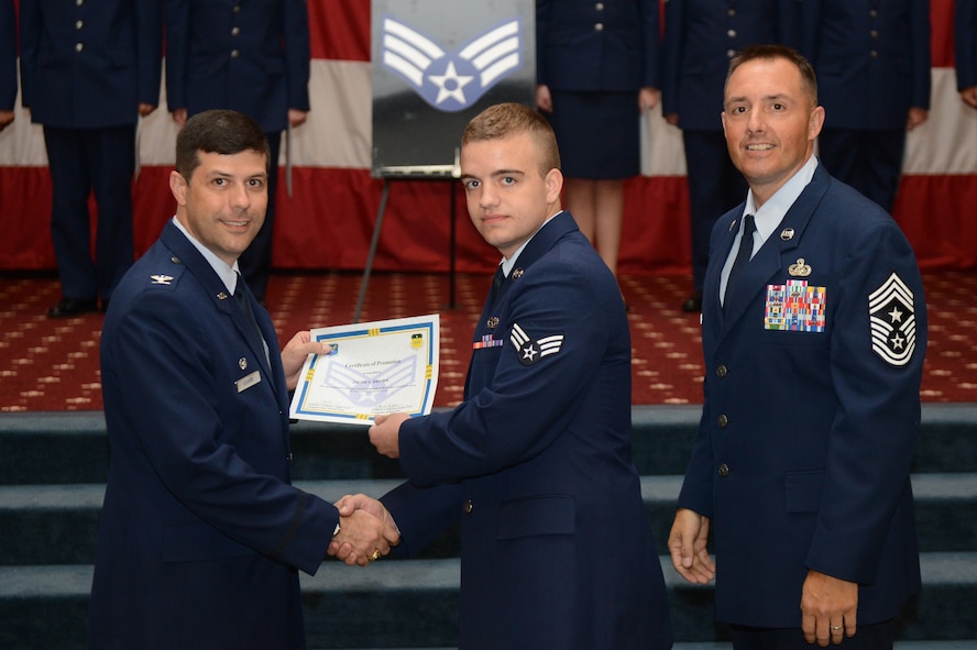 Senior Airman Jacob Brown, from the 2nd Munitions Squadron, receives a certificate of promotion from Col. Andrew Gebara, 2nd Bomb Wing commander, and Chief Master Sgt. Curtis Storms, 2nd BW command chief, during the July Wing Promotion Ceremony on Barksdale Air Force Base, La., July 31, 2013. (U.S. Air Force photo/Senior Airman Micaiah Anthony)