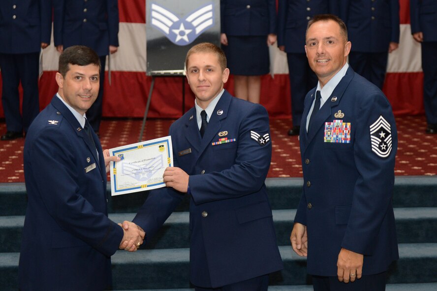 Senior Airman Andrew Melanson, from the 2nd Maintenance Squadron, receives a certificate of promotion from Col. Andrew Gebara, 2nd Bomb Wing commander, and Chief Master Sgt. Curtis Storms, 2nd BW command chief, during the July Wing Promotion Ceremony on Barksdale Air Force Base, La., July 31, 2013. (U.S. Air Force photo/Senior Airman Micaiah Anthony)