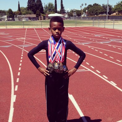 Omari Davis poses for a picture with his track and field medals at Beale Air Force Base Calif. Davis is currently competing in the Hershey’s Track and Field North American Finals starting on August 1, 2013, in Hershey, Penn. (Courtesy photo/Released)