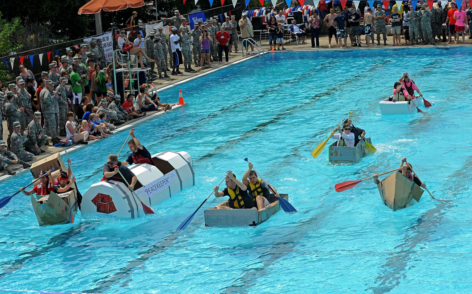 Members from Team Scott participate in the 3rd annual Cardboard Boat regatta at the Scott pool Aug. 2, 2013. The race, hosted by the 375th Force Support Squadron, featured 23 teams and gave away prizes for the best decorated boat, faster sinking boat and best dressed contestants.  Gift cards were also given to the first, second and third place winners. (U.S. Air Force photo/Senior Airman Divine Cox)