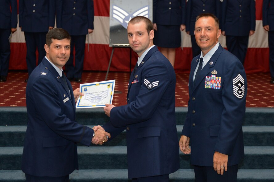 Senior Airman Shawn Hagmeier, from the 2nd Maintenance Squadron, receives a certificate of promotion from Col. Andrew Gebara, 2nd Bomb Wing commander, and Chief Master Sgt. Curtis Storms, 2nd BW command chief, during the July Wing Promotion Ceremony on Barksdale Air Force Base, La., July 31, 2013. (U.S. Air Force photo/Senior Airman Micaiah Anthony)