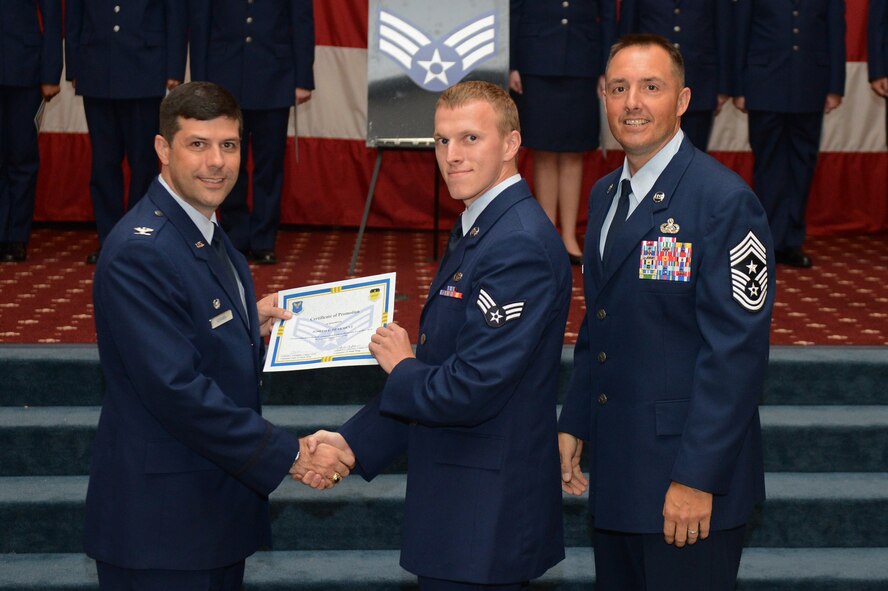 Senior Airman Joseph Dearment, from the 2nd Maintenance Squadron, receives a certificate of promotion from Col. Andrew Gebara, 2nd Bomb Wing commander, and Chief Master Sgt. Curtis Storms, 2nd BW command chief, during the July Wing Promotion Ceremony on Barksdale Air Force Base, La., July 31, 2013. (U.S. Air Force photo/Senior Airman Micaiah Anthony)