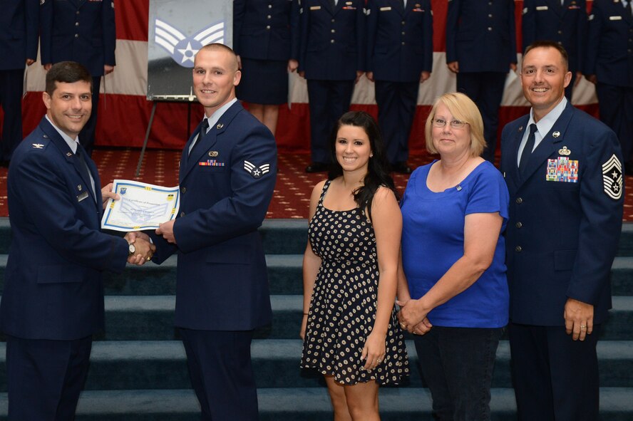 Senior Airman Benjamin Jordan, from the 2nd Maintenance Operation Squadron, receives a certificate of promotion from Col. Andrew Gebara, 2nd Bomb Wing commander, and Chief Master Sgt. Curtis Storms, 2nd BW command chief, during the July Wing Promotion Ceremony on Barksdale Air Force Base, La., July 31, 2013. (U.S. Air Force photo/Senior Airman Micaiah Anthony)