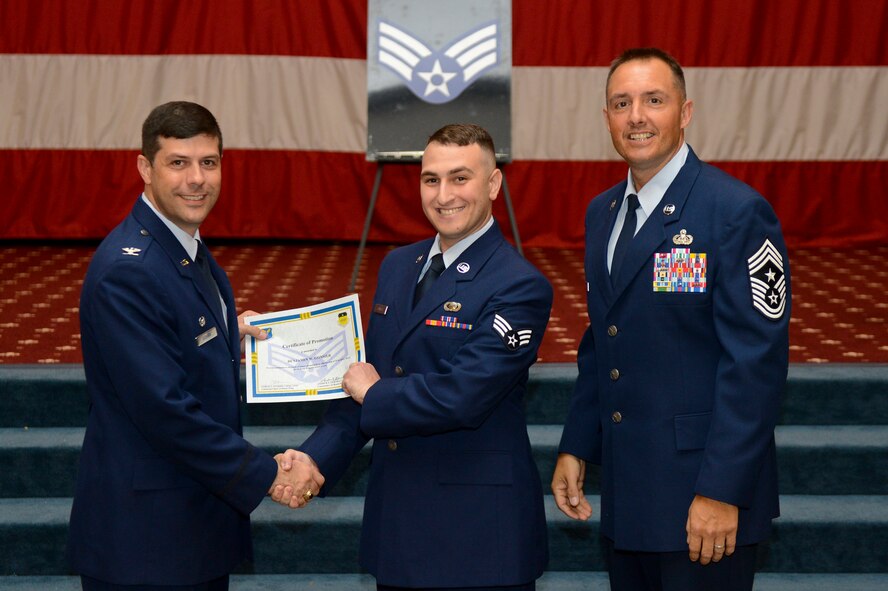 Senior Airman Benjamin Gonsier, from the 2nd Bomb Wing, receives a certificate of promotion from Col. Andrew Gebara, 2nd Bomb Wing commander, and Chief Master Sgt. Curtis Storms, 2nd BW command chief, during the July Wing Promotion Ceremony on Barksdale Air Force Base, La., July 31, 2013. (U.S. Air Force photo/Senior Airman Micaiah Anthony)