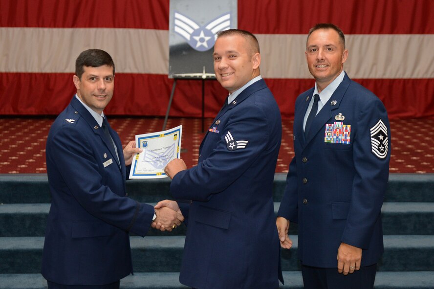 Senior Airman Jean Schornberg, from the 2nd Aircraft Maintenance Squadron, receives a certificate of promotion from Col. Andrew Gebara, 2nd Bomb Wing commander, and Chief Master Sgt. Curtis Storms, 2nd BW command chief, during the July Wing Promotion Ceremony on Barksdale Air Force Base, La., July 31, 2013. (U.S. Air Force photo/Senior Airman Micaiah Anthony)