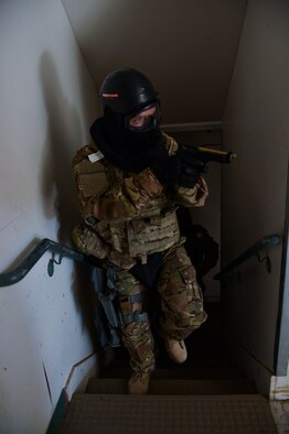 Staff Sgt. Dustin Barnes, 56th SFS military working dog handler, leads his team up the stairs as they clear the building of suspects during the training. (U.S. Air Force photo/Senior Airman David Owsianka)
