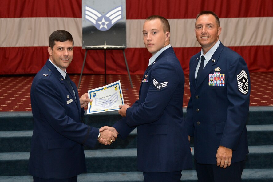 Senior Airman Nicholas Pierce, from the 2nd Aircraft Maintenance Squadron receives, a certificate of promotion from Col. Andrew Gebara, 2nd Bomb Wing commander, and Chief Master Sgt. Curtis Storms, 2nd BW command chief, during the July Wing Promotion Ceremony on Barksdale Air Force Base, La., July 31, 2013. (U.S. Air Force photo/Senior Airman Micaiah Anthony)